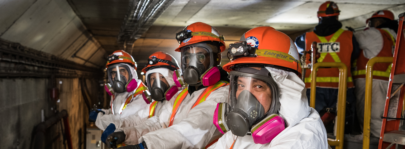 TTC employees underground in a subway tunnel doing construction on line one. All employees are wearing personal protective equipment. 