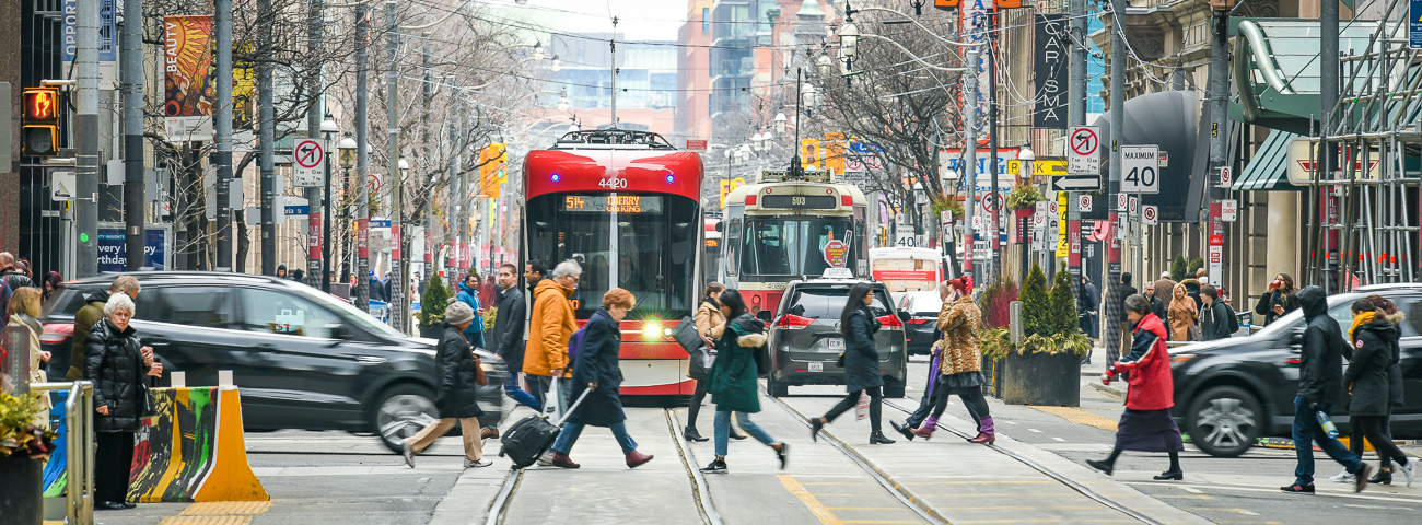 Image of two streetcars on a busy downtown street