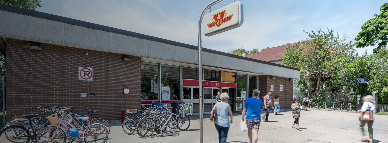 Commuters walking by bike stand located near entrance of Chester Station on a sunny day